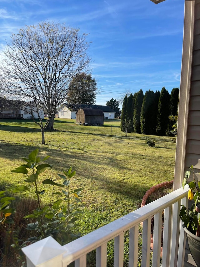 view of yard featuring a storage shed and a balcony