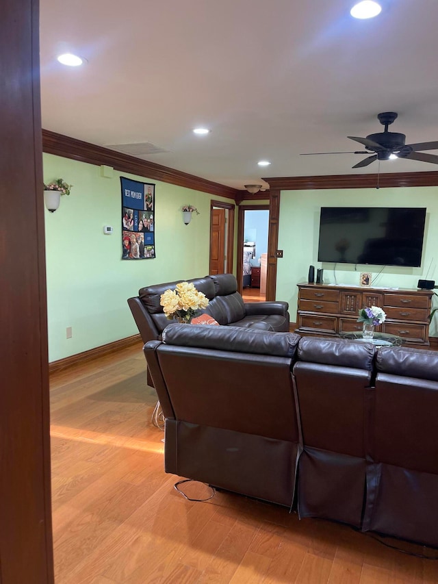 living room with ornamental molding, light hardwood / wood-style floors, and ceiling fan