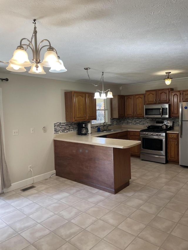 kitchen with pendant lighting, tasteful backsplash, kitchen peninsula, stainless steel appliances, and an inviting chandelier