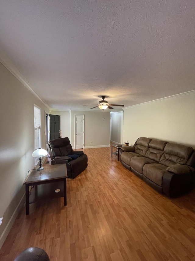 living room featuring crown molding, ceiling fan, a textured ceiling, and hardwood / wood-style flooring