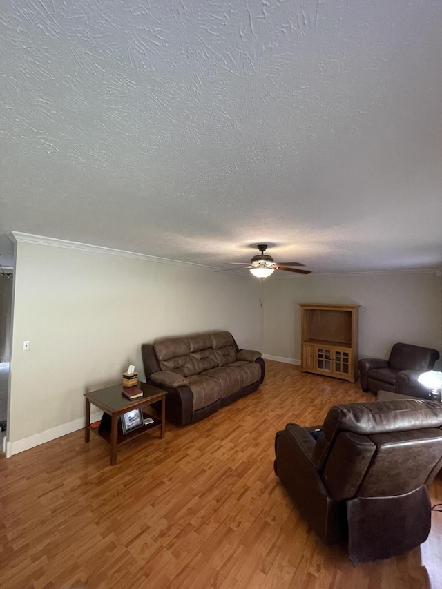 living room with hardwood / wood-style flooring, crown molding, ceiling fan, and a textured ceiling