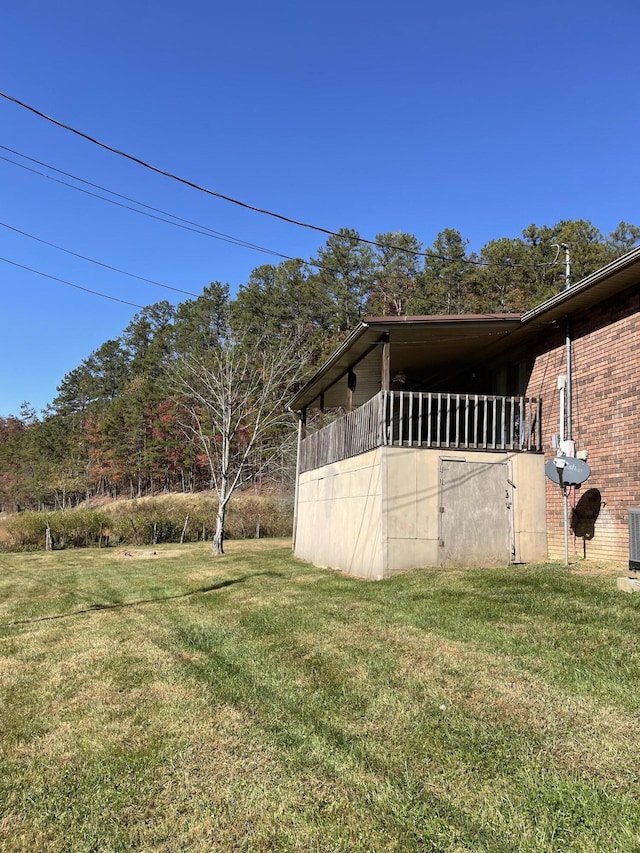 view of side of property with a yard and central AC unit