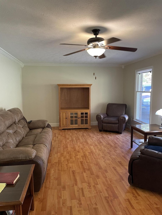 living room featuring ornamental molding, ceiling fan, a textured ceiling, and light hardwood / wood-style flooring