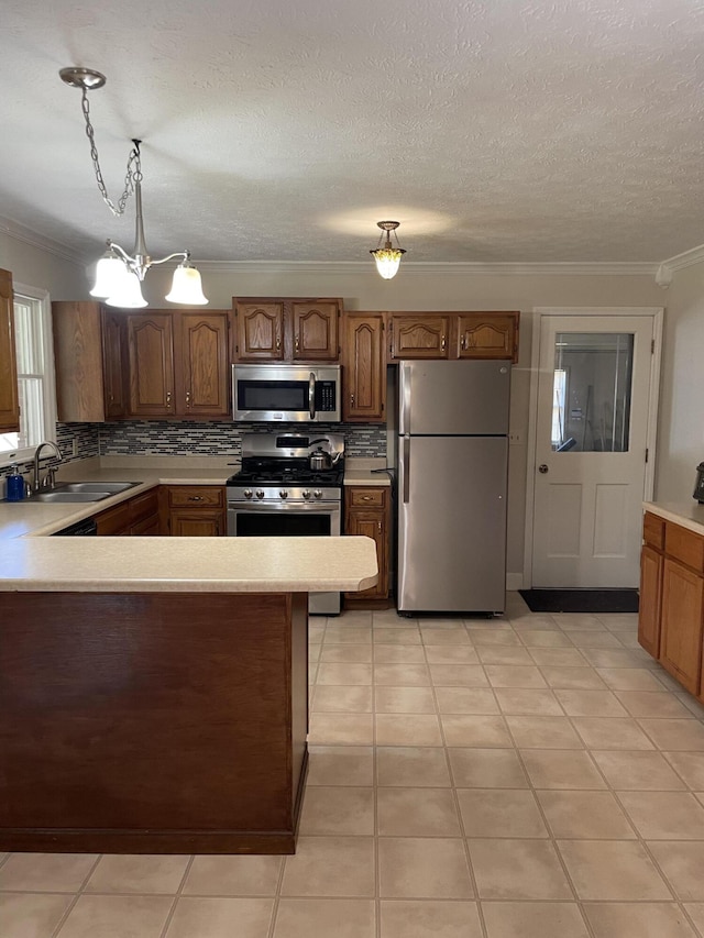 kitchen featuring pendant lighting, appliances with stainless steel finishes, sink, and tasteful backsplash