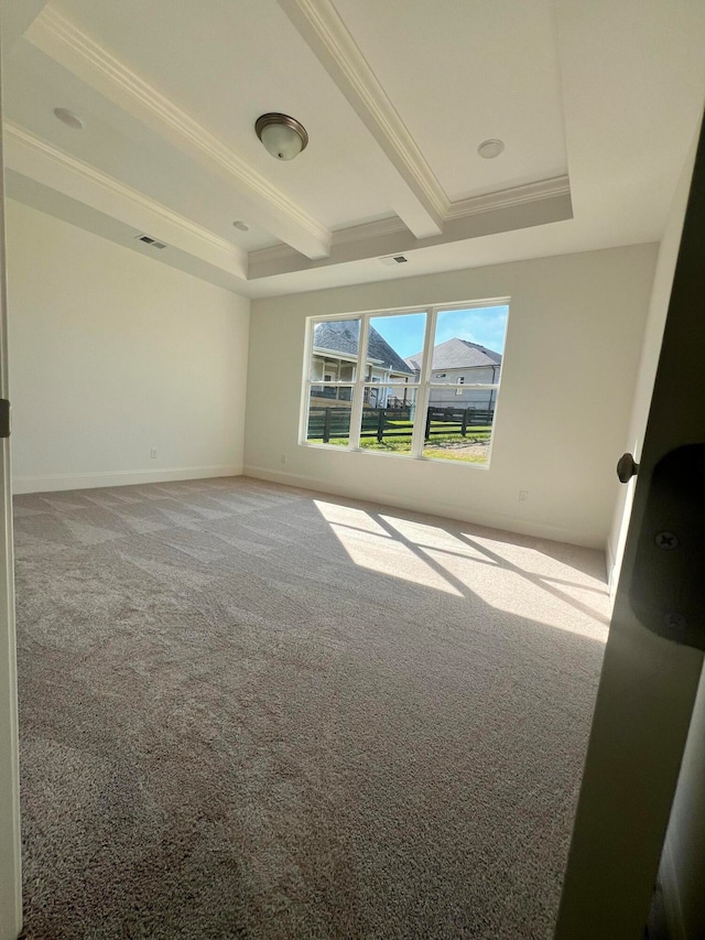 empty room featuring beam ceiling, carpet, crown molding, and a raised ceiling