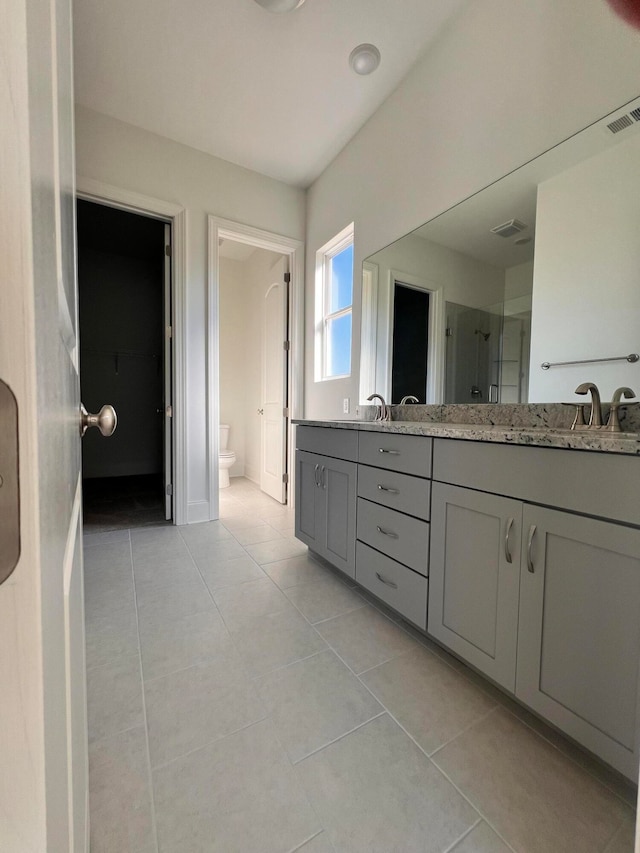 bathroom with toilet, an enclosed shower, vanity, and tile patterned flooring