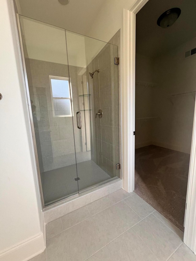 bathroom with tile patterned floors and walk in shower