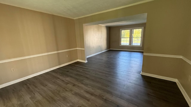 spare room with crown molding and dark hardwood / wood-style floors