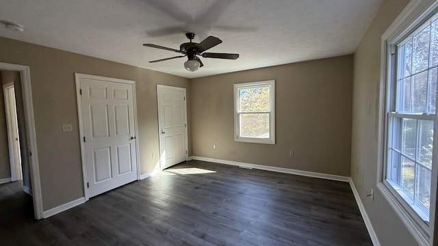 unfurnished bedroom with dark wood-type flooring and ceiling fan