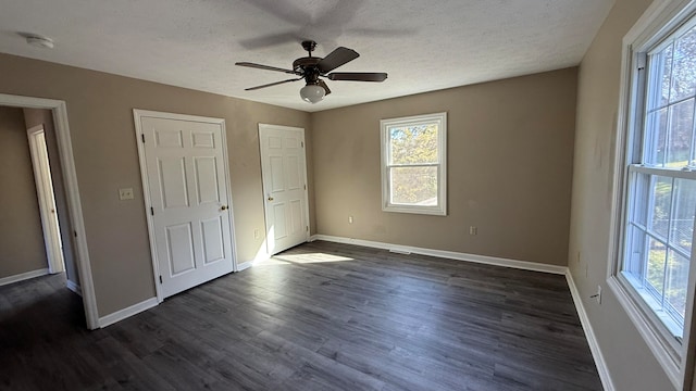 unfurnished bedroom with dark hardwood / wood-style floors, a textured ceiling, and ceiling fan