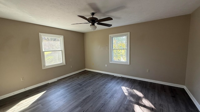 empty room with dark wood-type flooring, ceiling fan, and a textured ceiling