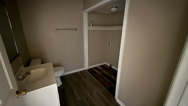 bathroom featuring toilet, hardwood / wood-style floors, and vanity