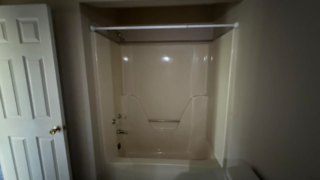 bathroom with shower / bathing tub combination and toilet