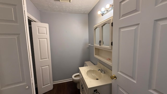 bathroom with vanity, toilet, a textured ceiling, and hardwood / wood-style floors