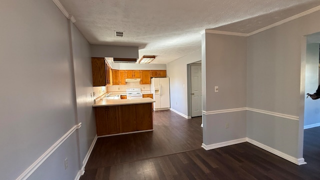 kitchen featuring white appliances, dark wood-type flooring, a textured ceiling, and kitchen peninsula