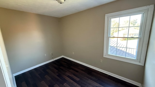 spare room with dark wood-type flooring