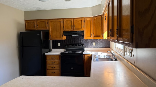 kitchen with decorative backsplash, black appliances, sink, and a textured ceiling