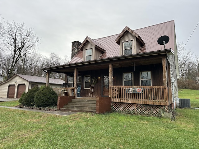 view of front of property featuring central AC, a front yard, covered porch, a garage, and an outbuilding