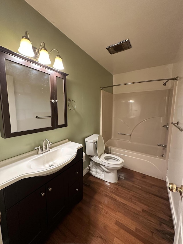 full bathroom with toilet, hardwood / wood-style floors, vanity, and tub / shower combination