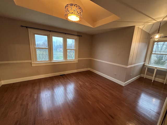 spare room with lofted ceiling and dark wood-type flooring