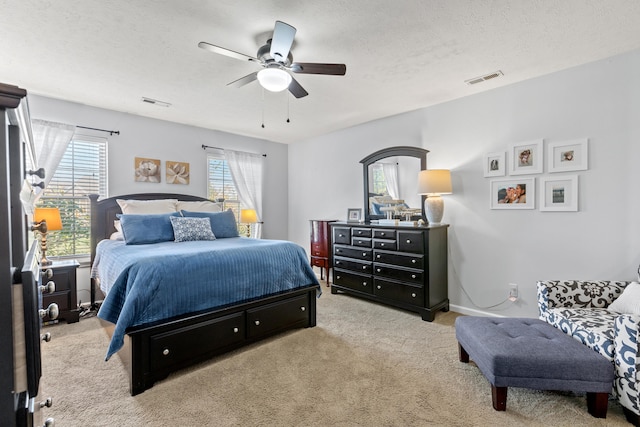 carpeted bedroom with ceiling fan and a textured ceiling