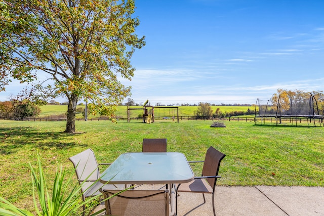 view of yard with a rural view, a trampoline, and a patio