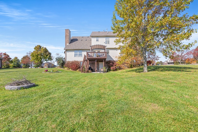 rear view of house featuring a wooden deck and a lawn