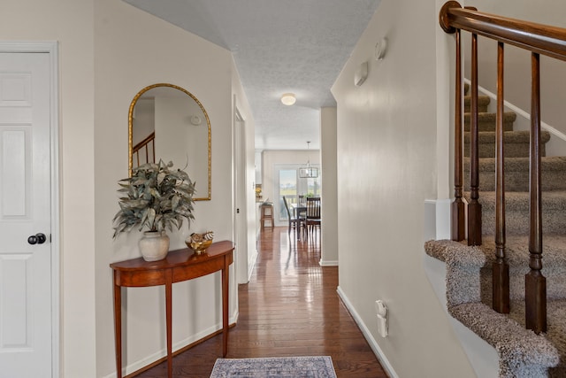 hallway featuring a textured ceiling and dark hardwood / wood-style floors