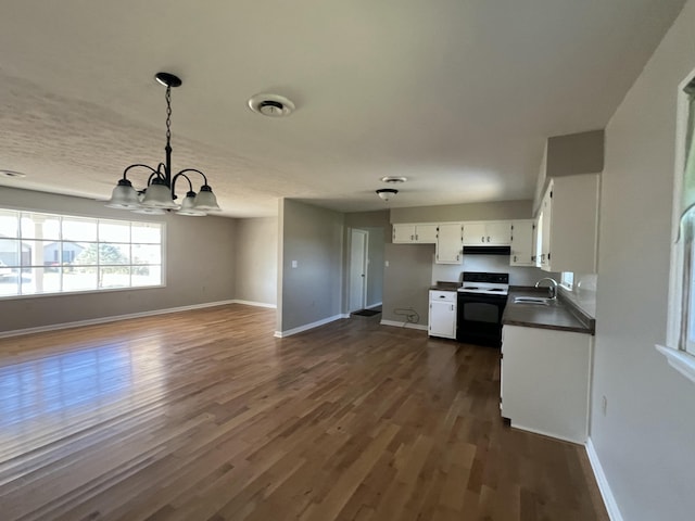 kitchen featuring sink, hanging light fixtures, electric range, a notable chandelier, and white cabinetry