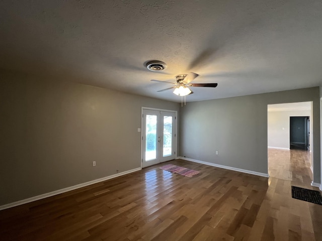 spare room featuring ceiling fan, dark hardwood / wood-style flooring, a textured ceiling, and french doors