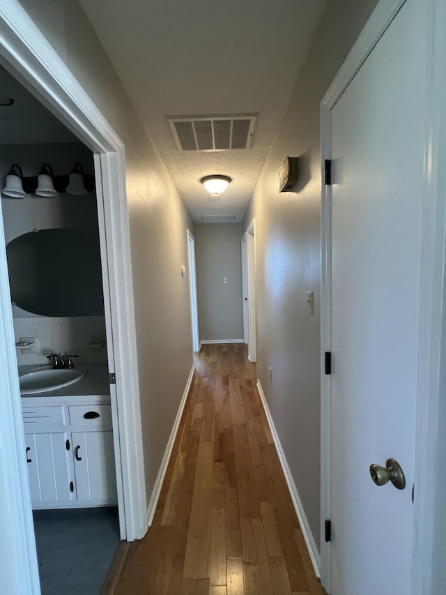 hallway featuring sink and dark wood-type flooring