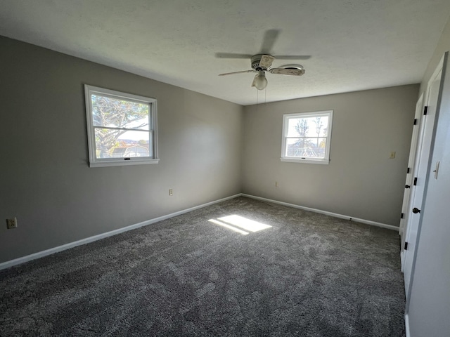 carpeted empty room featuring ceiling fan and a wealth of natural light