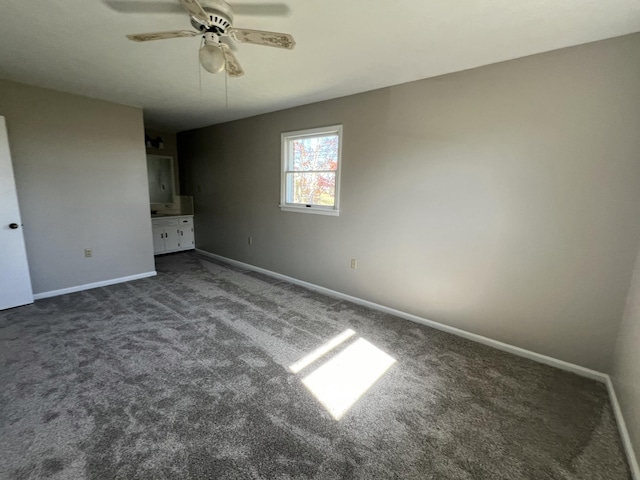 unfurnished bedroom featuring ceiling fan and dark carpet