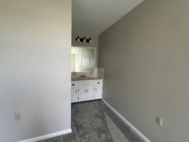 hall featuring dark carpet and sink