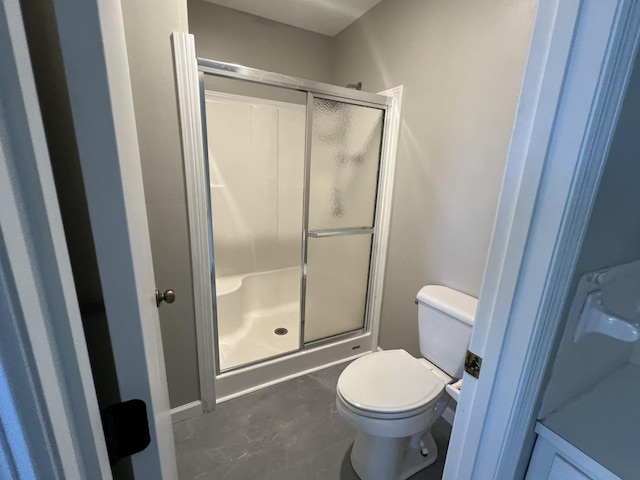 bathroom featuring toilet and an enclosed shower