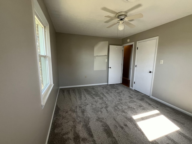 unfurnished bedroom with ceiling fan and dark carpet