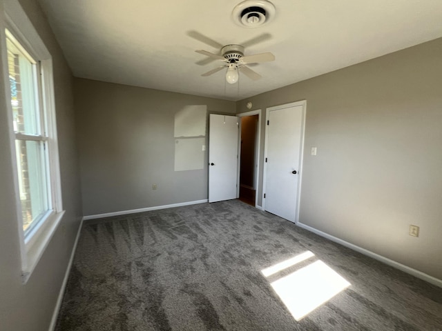 unfurnished bedroom featuring dark colored carpet and ceiling fan