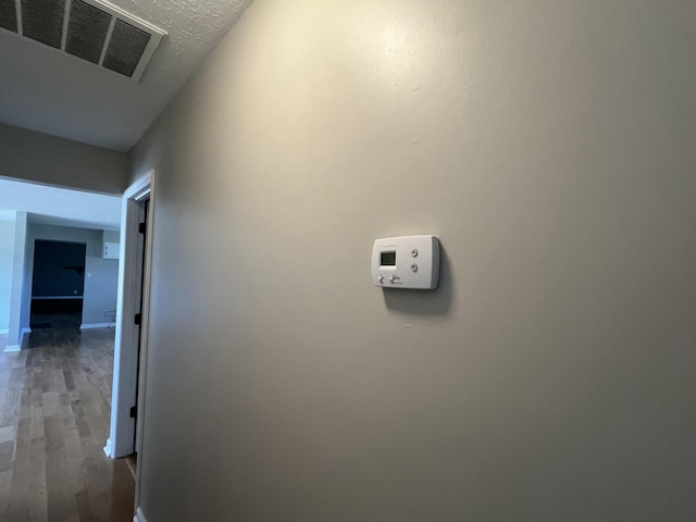 hall with hardwood / wood-style floors and a textured ceiling