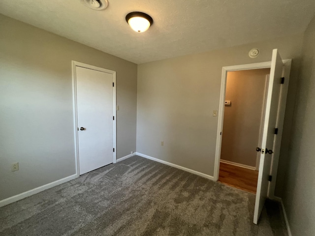 carpeted spare room with a textured ceiling