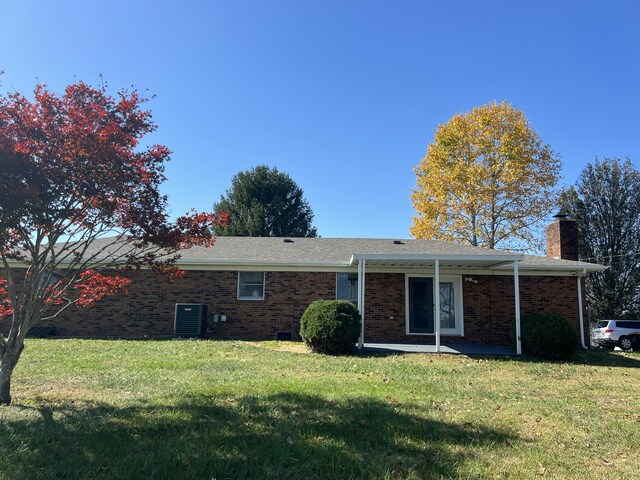 view of front facade with central AC and a front lawn