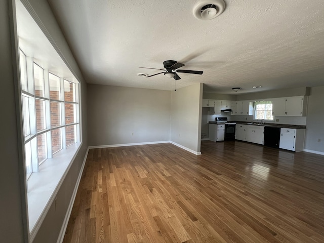 unfurnished living room with ceiling fan, wood-type flooring, and a textured ceiling