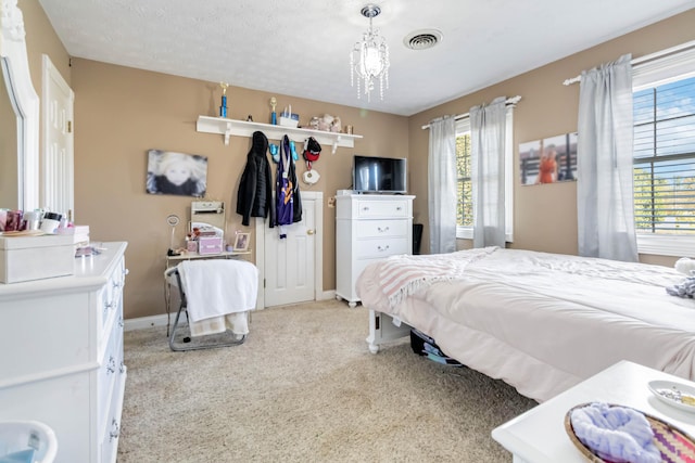 bedroom featuring light carpet, a notable chandelier, a textured ceiling, and multiple windows