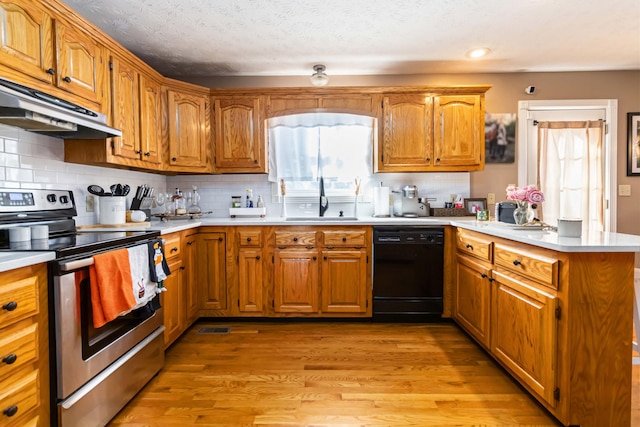 kitchen featuring sink, dishwasher, stainless steel range with electric stovetop, kitchen peninsula, and light hardwood / wood-style floors