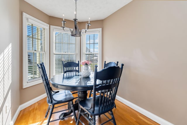 dining room featuring a textured ceiling, hardwood / wood-style flooring, and a chandelier