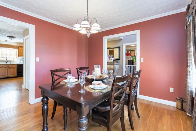 dining room featuring a textured ceiling, plenty of natural light, light hardwood / wood-style floors, crown molding, and a chandelier