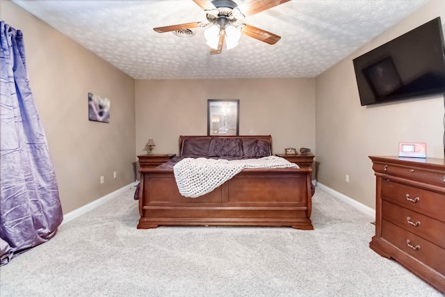 bedroom with ceiling fan, a textured ceiling, and light colored carpet