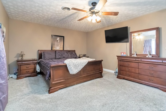 carpeted bedroom with a textured ceiling and ceiling fan