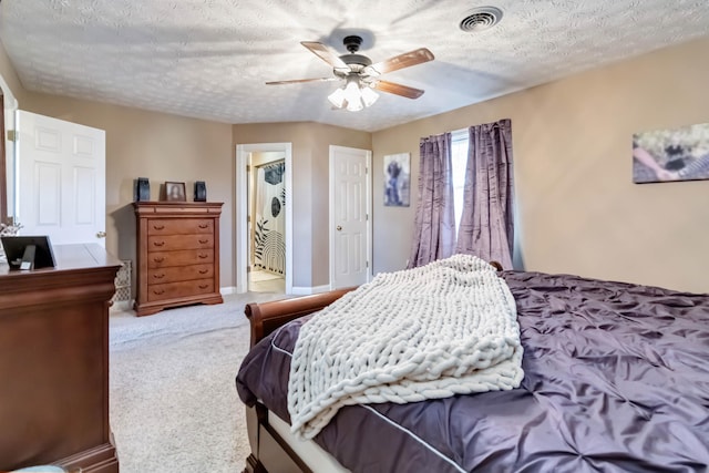 bedroom with ceiling fan, carpet flooring, and a textured ceiling