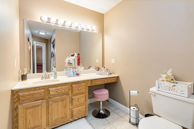 bathroom with toilet, vanity, and tile patterned flooring