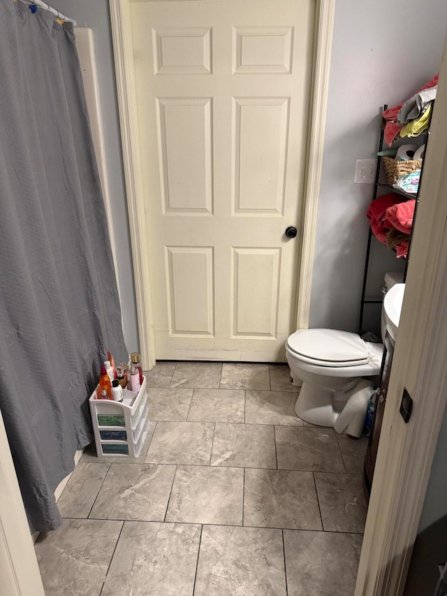 bathroom featuring toilet and walk in shower